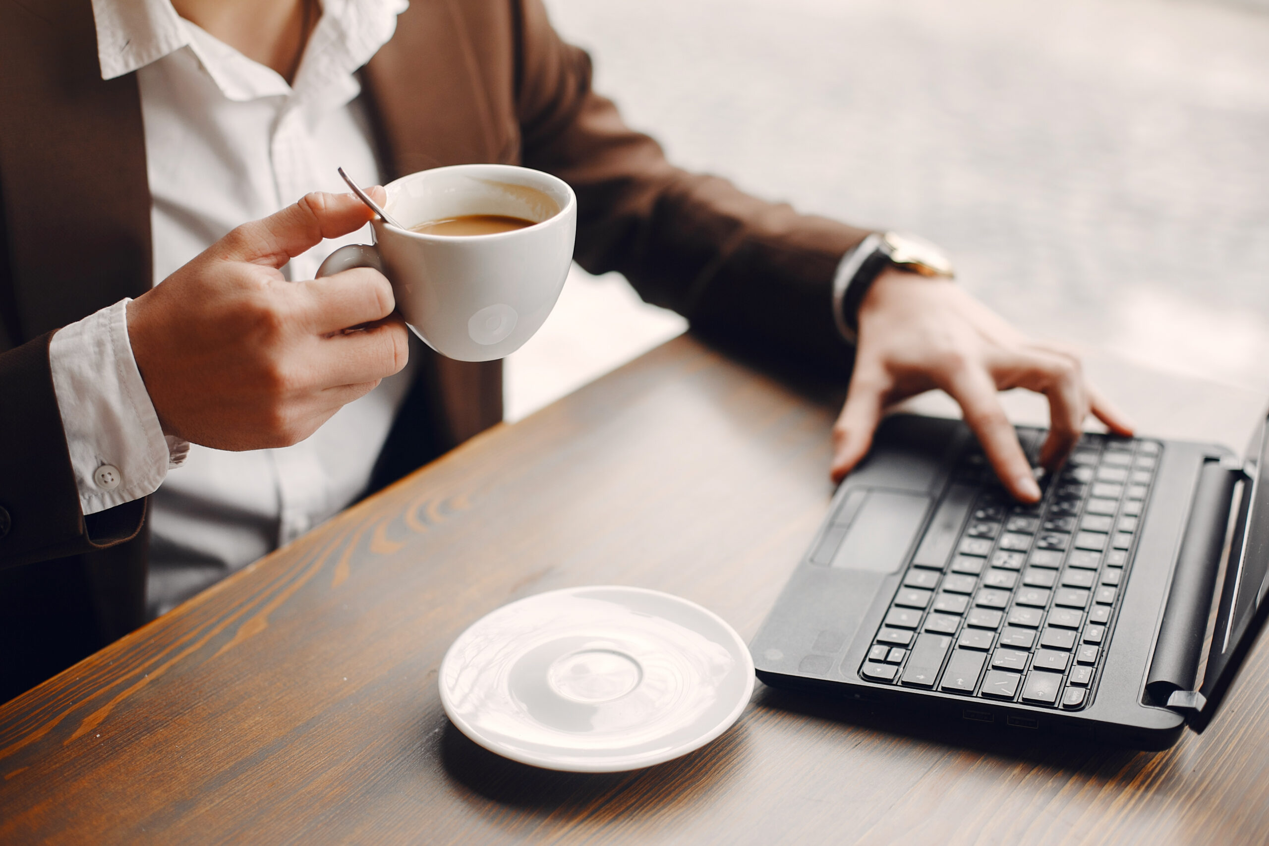 Handsome man in a black suit. Businessman working in a cafe